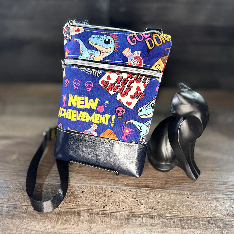small crossbody phone bag with a cartoon of a man and a cat